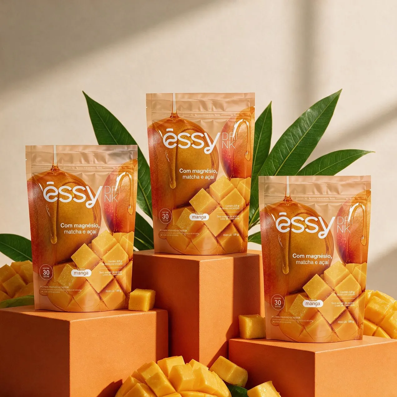 Embalagens de Êssy Drink com folhas de mangueira